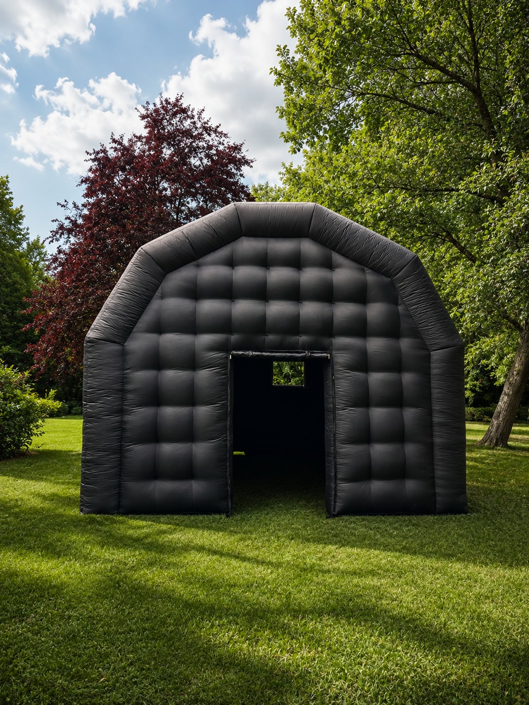 De zwarte opblaasbare tent van buiten op een grasveld